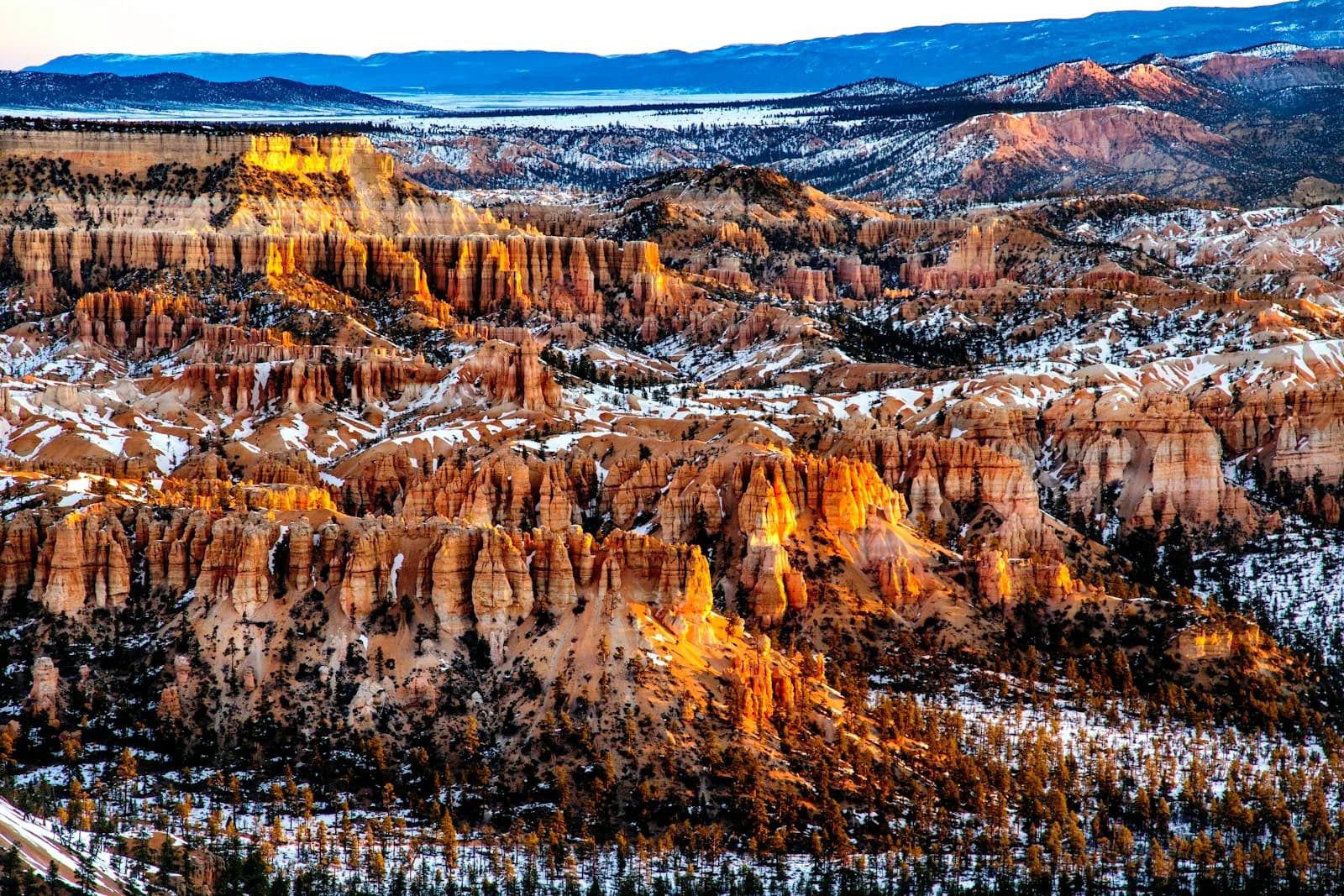 La nieve resalta las rocas naranjas de Bryce Canyon al amanecer
