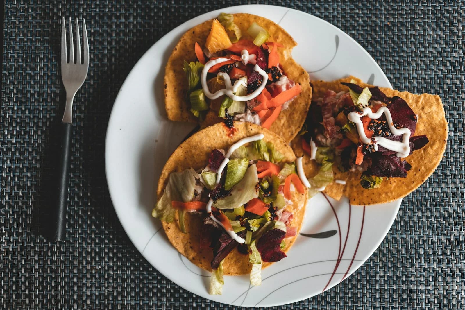 Three filled tacos arranged on a plate